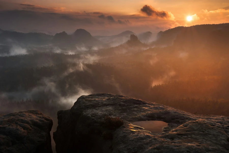 Eindrucksvolle Berglandschaft mit Sonnenuntergang im Hintergrund.